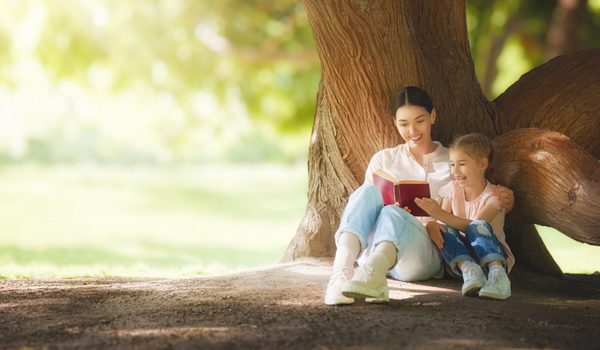 mom reading to daughter in nature encouraging a growth mindset in our kids