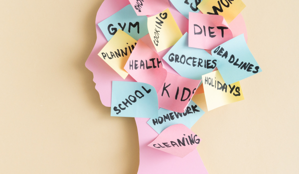 Woman’s head silhouette covered in sticky notes representing the mental load women carry and constant mental tasks