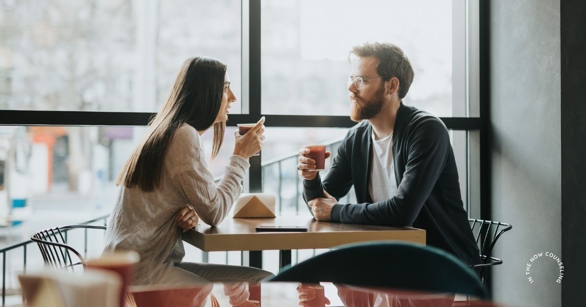 Man and woman having a thoughtful conversation over coffee about what to discuss before marriage