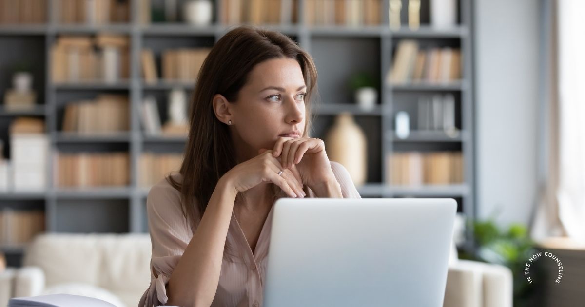 Woman sitting alone looking thoughtful and unhappy in her marriage, reflecting on relationship stress