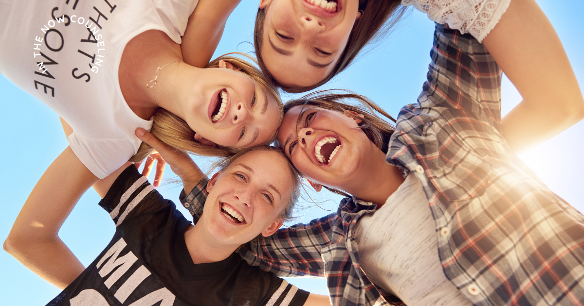 teens huddled together smiling in summer