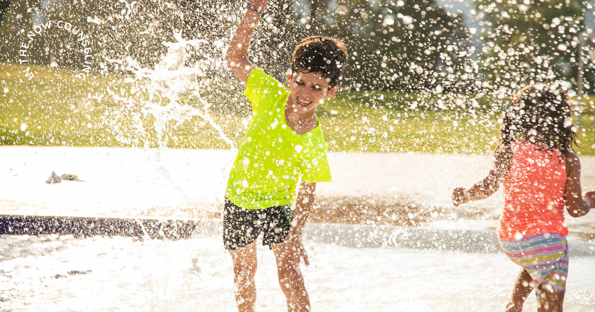 a boy and a girl yelling and splashing in water
