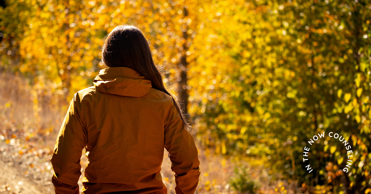 moms surrounded by fall leaves taking a moment to help the overwhelmed nature of the season.